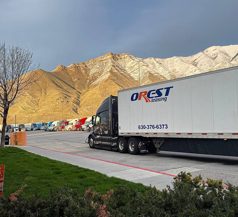 An OREST Express tractor-trailer parked in front of mountains